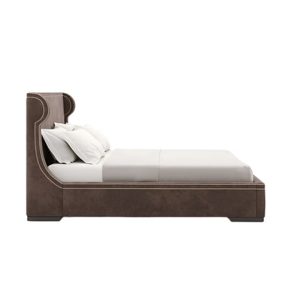Brown upholstered bed with high curved headboard and white bedding